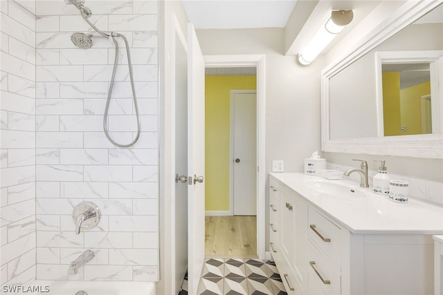 bathroom featuring tiled shower / bath combo and vanity