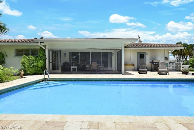 view of swimming pool with a patio area and a grill