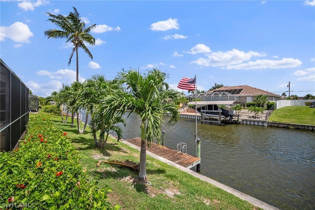 view of dock with a water view, a lanai, and a lawn