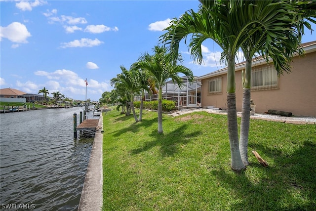 view of dock featuring a yard, a water view, and a lanai