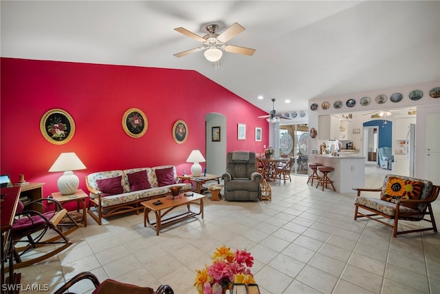 living room featuring lofted ceiling, ceiling fan, and light tile patterned floors