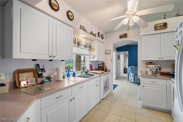 kitchen with white cabinetry, white refrigerator, sink, ceiling fan, and light tile patterned flooring