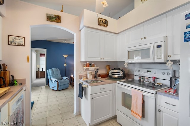 kitchen featuring white appliances, white cabinetry, and light tile patterned floors