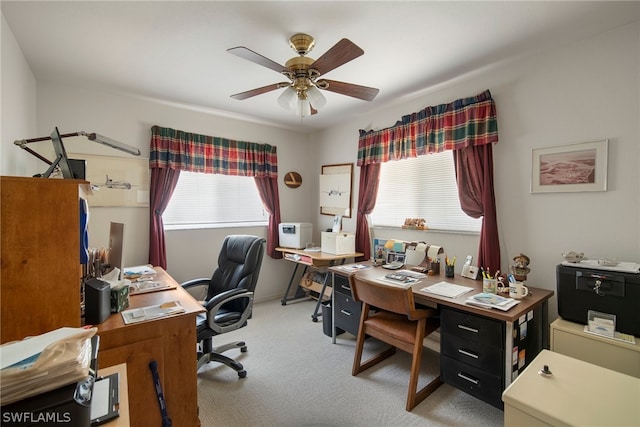 carpeted home office featuring ceiling fan