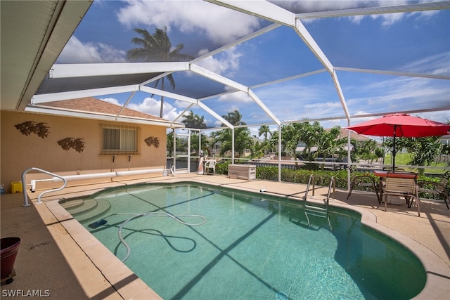 view of swimming pool with glass enclosure and a patio area