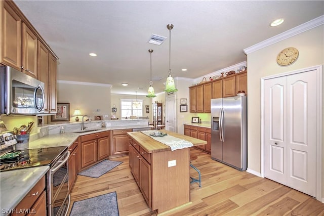 kitchen with a center island, sink, a breakfast bar area, light wood-type flooring, and stainless steel appliances