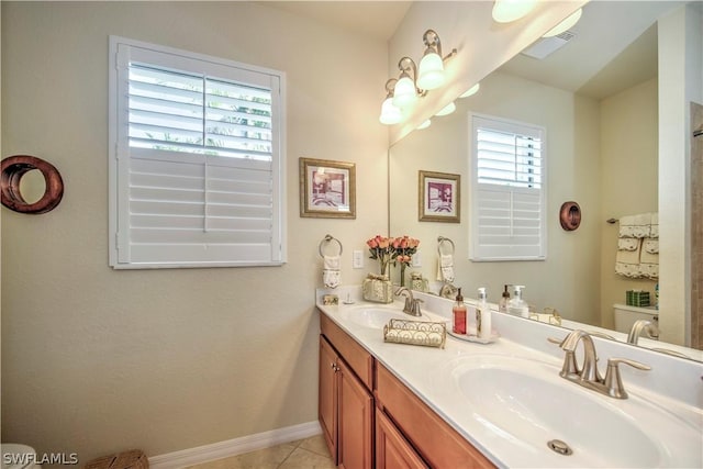 bathroom with a wealth of natural light, tile patterned flooring, and vanity