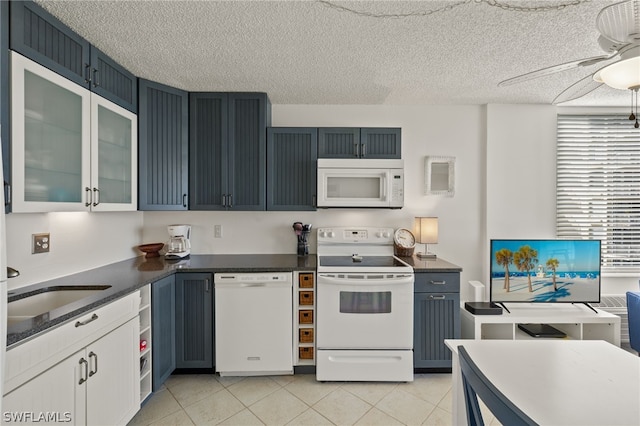 kitchen with white appliances, light tile patterned floors, ceiling fan, a textured ceiling, and white cabinetry