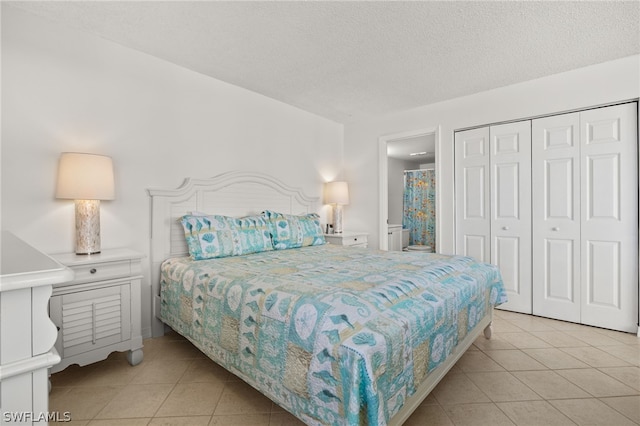 bedroom featuring a textured ceiling, a closet, and light tile patterned floors