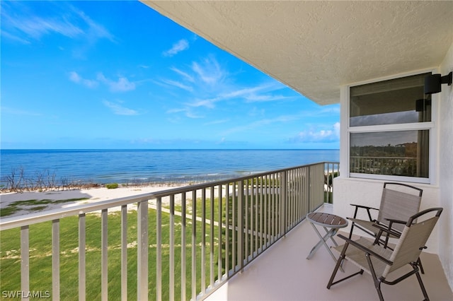 balcony with a beach view and a water view