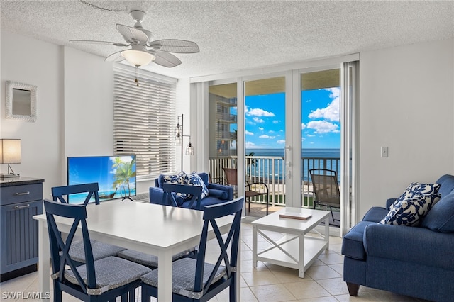 home office featuring light tile patterned floors, a textured ceiling, ceiling fan, and plenty of natural light