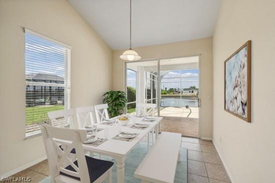 tiled dining area featuring a water view and plenty of natural light