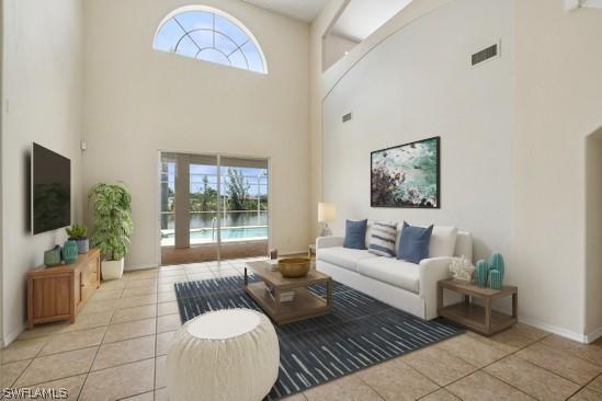 living room with light tile patterned floors and a high ceiling