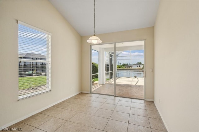 unfurnished dining area with light tile patterned floors and a water view