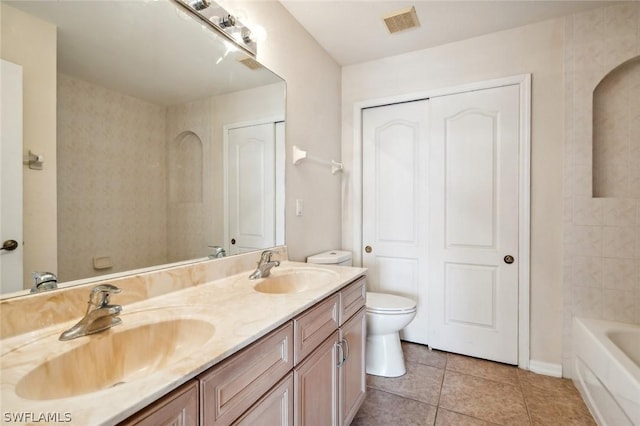 bathroom with toilet, vanity, and tile patterned floors