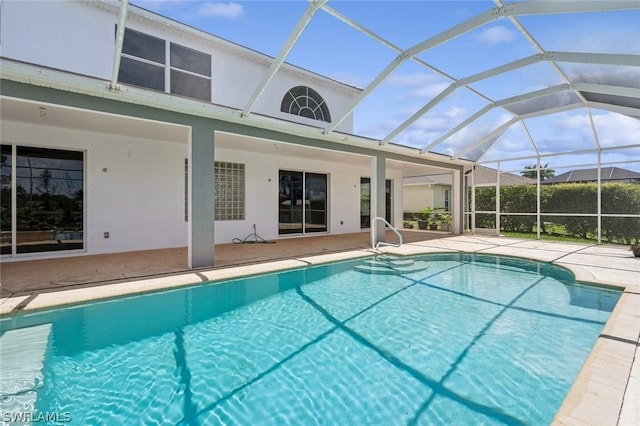 view of pool featuring glass enclosure and a patio area