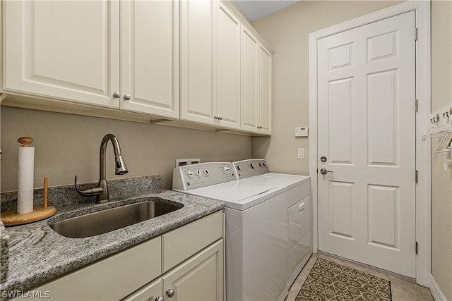 clothes washing area featuring washer and dryer, cabinets, light tile patterned floors, and sink