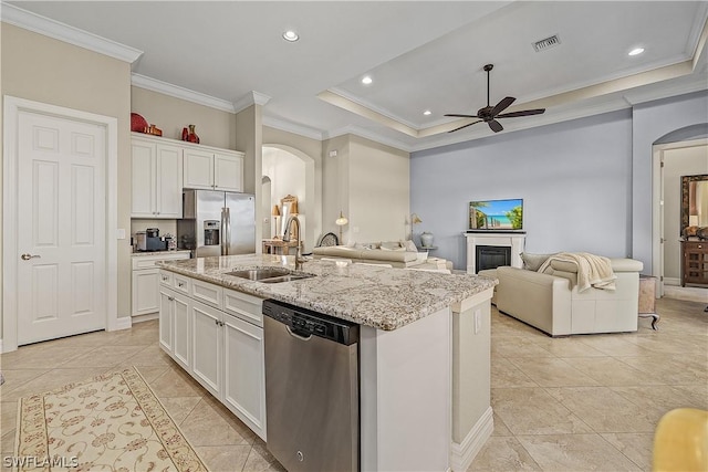 kitchen featuring stainless steel appliances, ceiling fan, a kitchen island with sink, sink, and white cabinetry