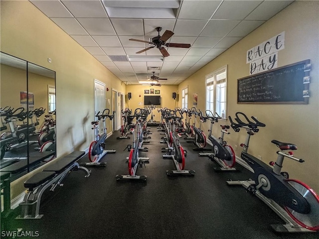 exercise room with a paneled ceiling and ceiling fan