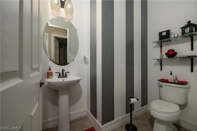 bathroom with toilet and tile patterned floors