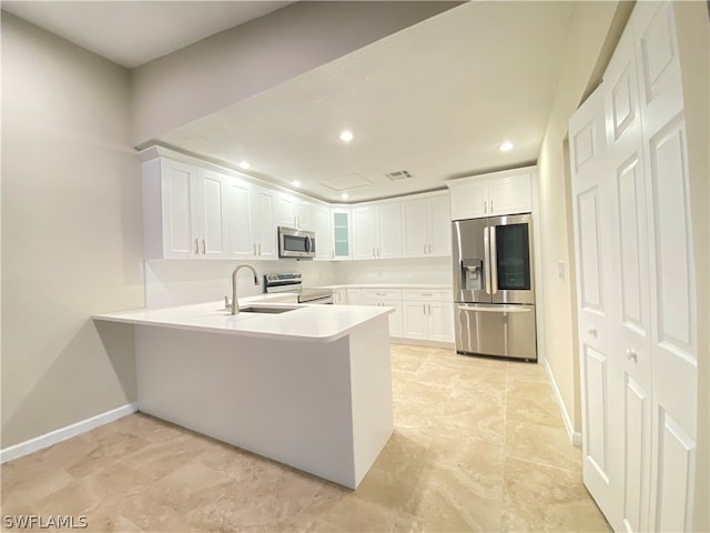 kitchen featuring white cabinetry, stainless steel appliances, sink, and kitchen peninsula