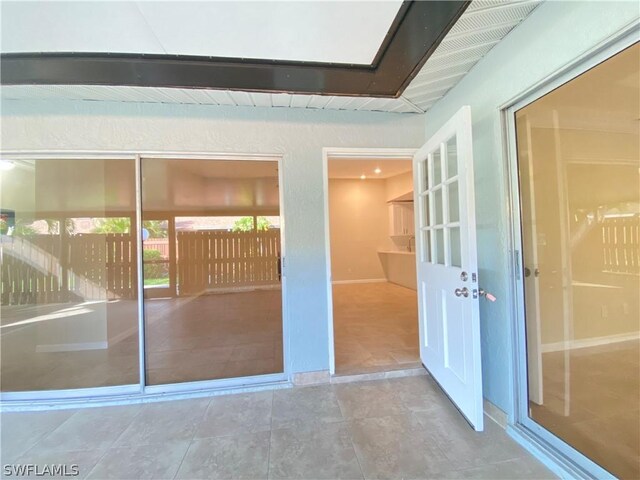 interior space with tile patterned floors and beamed ceiling