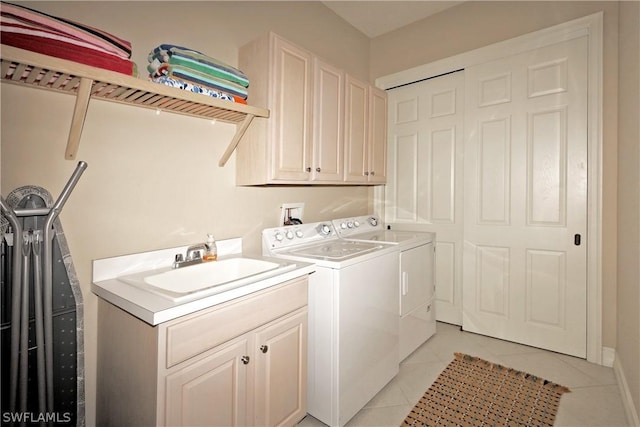 washroom with washer and dryer, light tile patterned flooring, cabinets, and sink