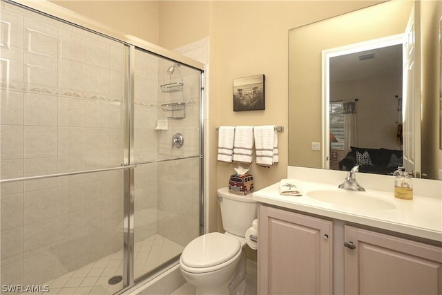 bathroom featuring vanity, an enclosed shower, and toilet