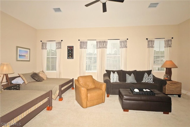 carpeted bedroom featuring multiple windows and ceiling fan