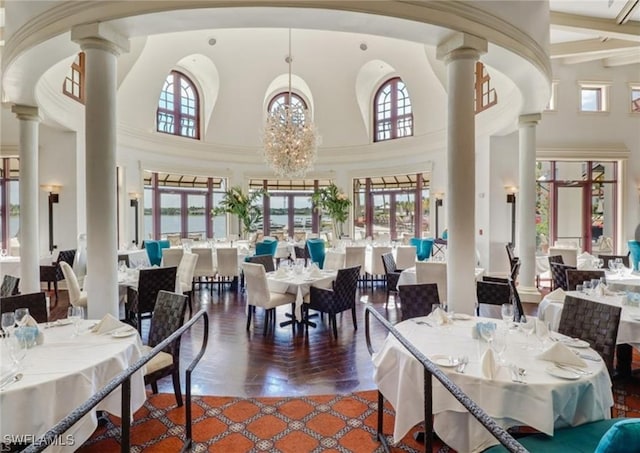 dining room with a chandelier, decorative columns, and plenty of natural light