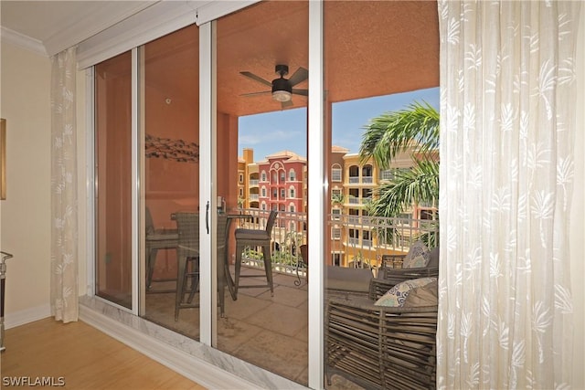 entryway with hardwood / wood-style flooring, ceiling fan, and crown molding