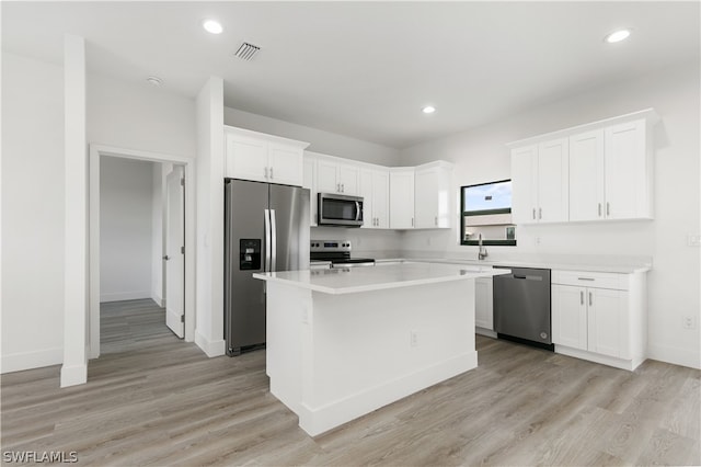 kitchen featuring a center island, white cabinetry, light wood-type flooring, and stainless steel appliances