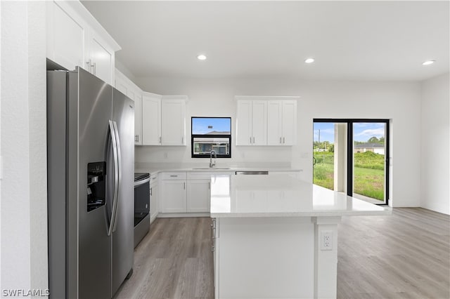 kitchen with stainless steel fridge with ice dispenser, white cabinetry, light hardwood / wood-style floors, and sink