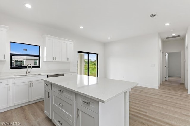 kitchen featuring sink, white cabinetry, light hardwood / wood-style flooring, and a kitchen island