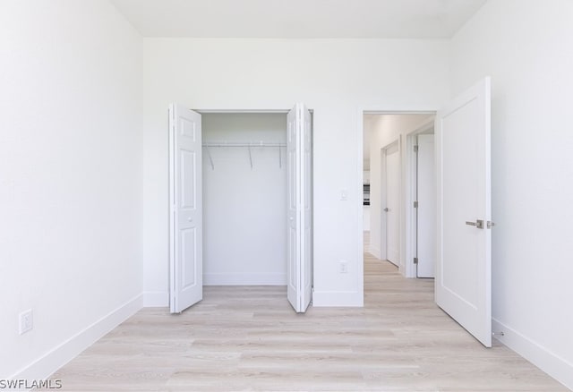 unfurnished bedroom featuring a closet and light hardwood / wood-style floors