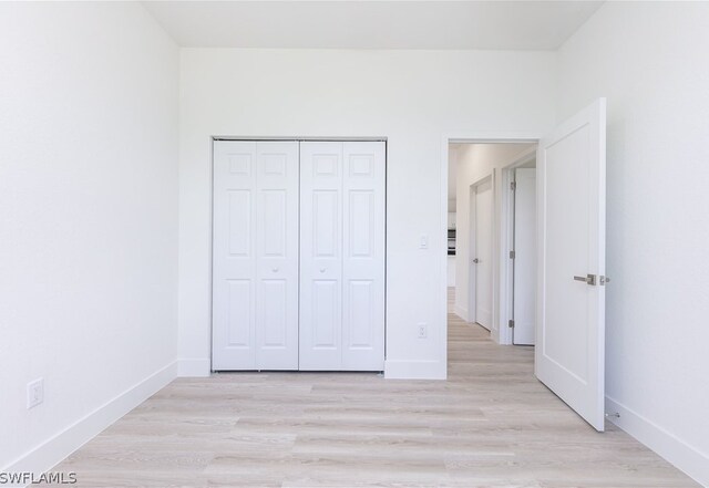 unfurnished bedroom featuring a closet and light wood-type flooring