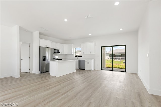 kitchen with a kitchen island, white cabinetry, light wood-type flooring, and stainless steel appliances