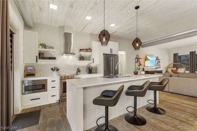 kitchen with sink, wall chimney exhaust hood, wooden ceiling, dark hardwood / wood-style floors, and appliances with stainless steel finishes