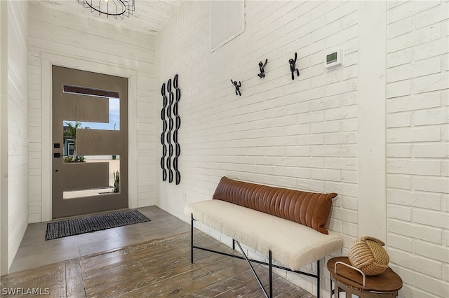 mudroom featuring brick wall