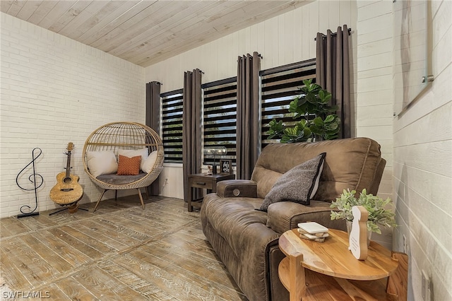 living area featuring hardwood / wood-style flooring, wooden walls, wood ceiling, and brick wall