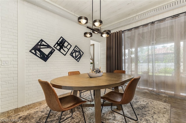 dining area featuring wood ceiling and brick wall