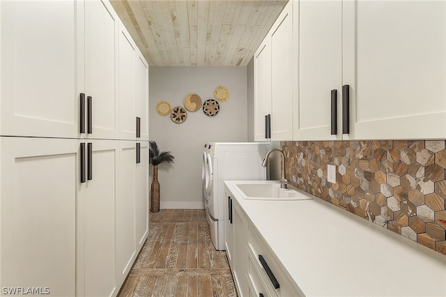 laundry area featuring cabinets, dark hardwood / wood-style flooring, wood ceiling, sink, and washer and dryer