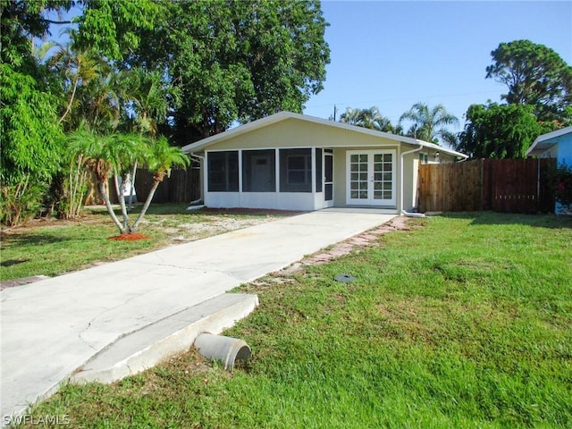 view of front of property featuring a sunroom and a front yard