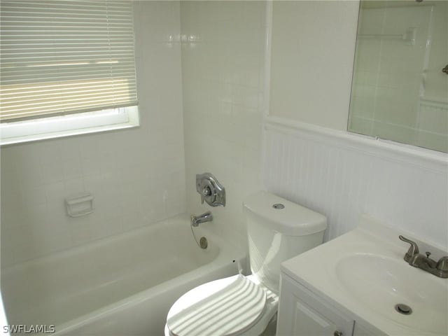 full bathroom with vanity, tiled shower / bath combo, and toilet