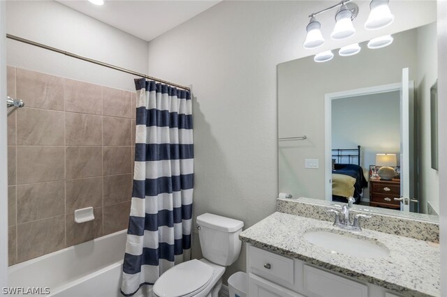 full bathroom featuring vanity, shower / tub combo with curtain, and toilet