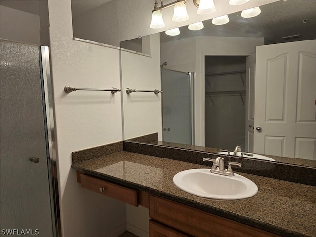 12940 Positano Cir Unit 201, Naples, FL 34105 - bathroom with a stall shower, vanity, and a walk in closet