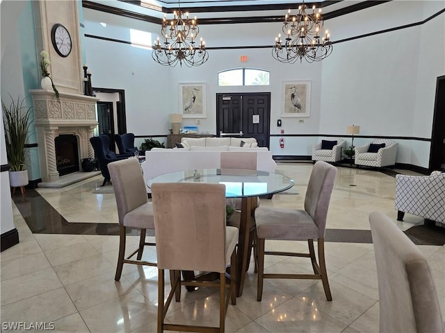 12940 Positano Cir Unit 201, Naples, FL 34105 - dining area with a chandelier, a high end fireplace, a high ceiling, baseboards, and light marble finish floors
