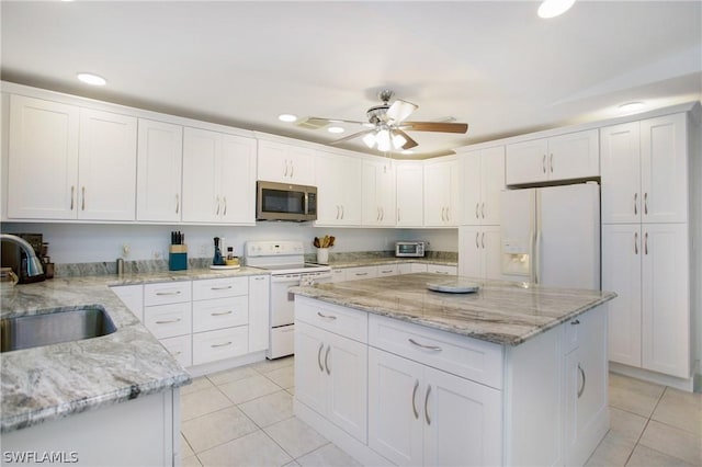 kitchen featuring a kitchen island, sink, white cabinets, light stone counters, and white appliances