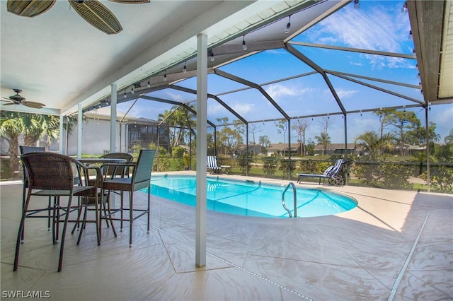 view of swimming pool featuring a lanai, ceiling fan, and a patio area