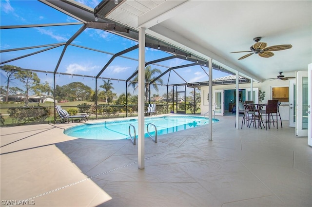 view of pool with a patio, ceiling fan, and glass enclosure